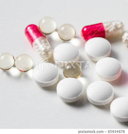 Red capsules and pills on a white background. Health care, medical, pharmacy and illness concept Red capsules and pills on a white background. Health care, medical, pharmacy and illness concept 85934876