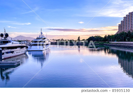 White yacht boats in private dock, pier, gradient orange and blue sky at sunset 85935130