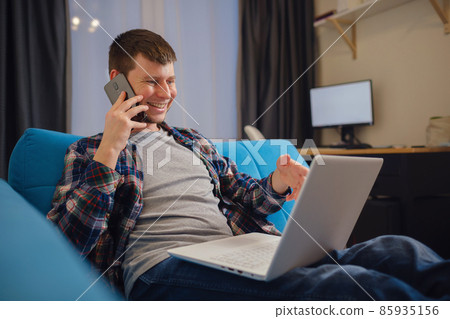 Handsome young man using laptop computer at home. 85935156