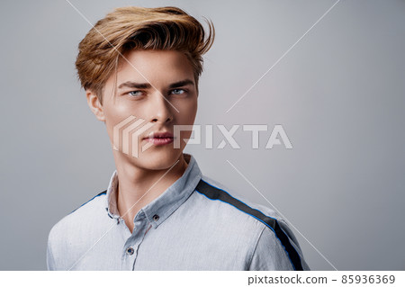 portrait of handsome young guy wearing shirt while looking at camera. Stylish hairstyle.  85936369
