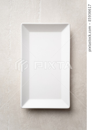 Rectangular white plate on a light stone background Rectangular white plate on a light stone background 85936617