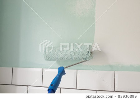 Paint rolle painting on surface wall. Renovation in house Paint rolle painting on surface wall. Renovation in house 85936899