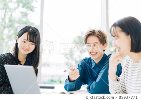 College students (men and women) looking at a computer in the classroom College students (men and women) looking at a computer in the classroom 85937771