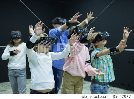 Excited tweens in VR glasses playing virtual reality games 85937977