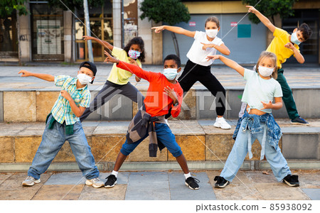 Kids in masks dancing on street 85938092