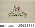 Bouquet of twigs with small white flowers, violets, poppies, twigs with blue flowers and a red-pink rose in the middle on a beige fabric background. 85938842