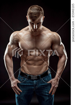Muscular bodybuilder guy doing posing over black background 85940105