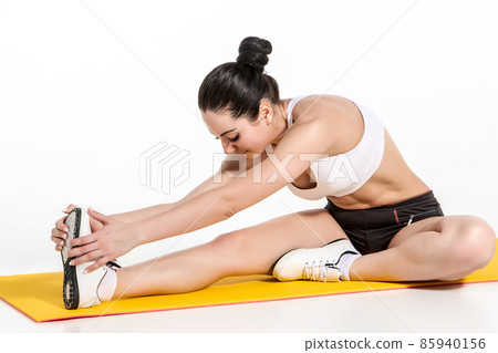 attractive woman doing exercises. Brunette fit body on yoga mat 85940156