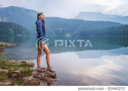 Young woman enjoying view of black lake or Crno jezero in Durmitor nature park, Montenegro 85940255