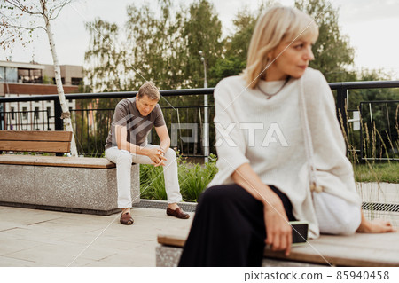 Mature couple in a bad mental condition after a quarrel outdoors. Adult couple man and woman trying to overcome anxiety and disorder after a break-up scene 85940458