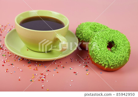 Multicolored donuts and a cup of coffee on a pink background. Multicolored donuts and a cup of coffee on a pink background. 85942950