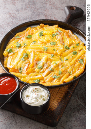 Chipsi mayai or zege is the most popular street food found all over Tanzania is a simple potato egg omelette close up on the table. Vertical Chipsi mayai or zege is the most popular street food found all over Tanzania is a simple potato egg omelette close up on the table. Vertical 85942996