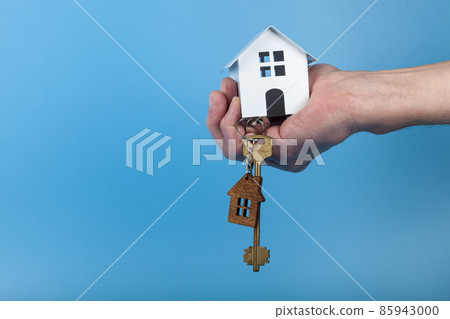 Hand with a toy house and keys. 85943000