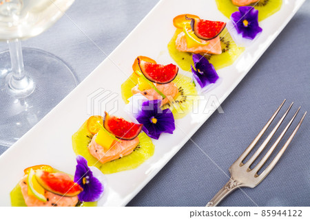 Ceviche of pickled salmon on kiwi with figs, cumquat 85944122