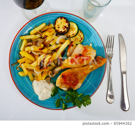 Dish with baked chicken legs and zucchini Dish with baked chicken legs and zucchini 85944162