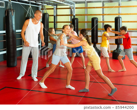 Kids exercising chin strike in gym 85944200