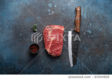Raw meat beef marbled prime cut steak Ribeye on rustic concrete kitchen table Raw meat beef marbled prime cut steak Ribeye on rustic concrete kitchen table 85944809