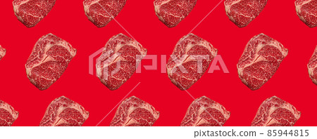 Pattern made of raw meat beef marbled prime cut steak Ribeye on red clean background Pattern made of raw meat beef marbled prime cut steak Ribeye on red clean background 85944815