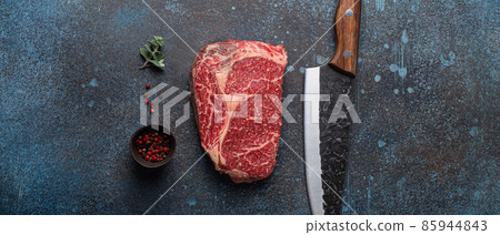 Raw meat beef marbled prime cut steak Ribeye on rustic concrete kitchen table Raw meat beef marbled prime cut steak Ribeye on rustic concrete kitchen table 85944843