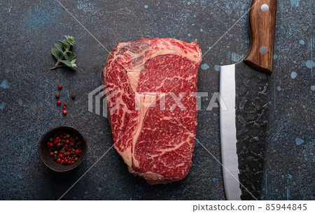 Raw meat beef marbled prime cut steak Ribeye on rustic concrete kitchen table Raw meat beef marbled prime cut steak Ribeye on rustic concrete kitchen table 85944845