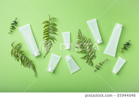 Skincare organic beauty product bottles, plant leaves on green background Skincare organic beauty product bottles, plant leaves on green background 85944846