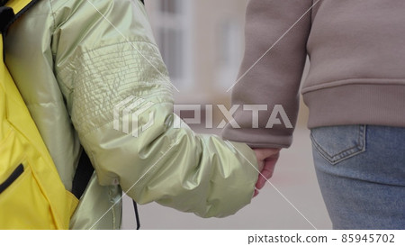 Mother takes hand of little daughter to follow to school Mother takes hand of little daughter to follow to school 85945702