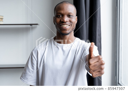Happy black man, looks at the camera, gives a thumbs up, everything is fine, the sign is satisfied with the service Happy black man, looks at the camera, gives a thumbs up, everything is fine, the sign is satisfied with the service 85947307