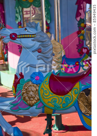 A merry-go-round blue horse ride. 85949435