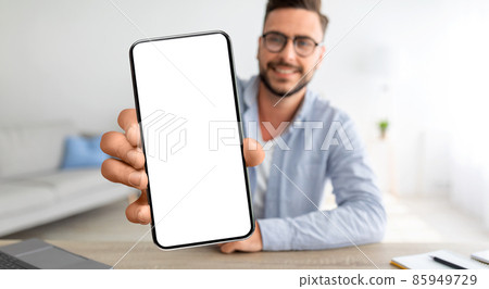 Online Ad. Smiling Young Guy Demonstrating Smartphone With Blank Screen At Home 85949729