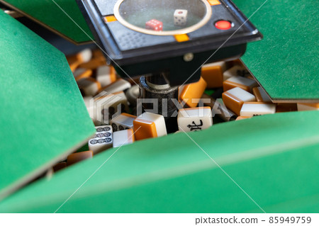 Mixing mahjong tiles at an electric mahjong table Mixing mahjong tiles at an electric mahjong table 85949759