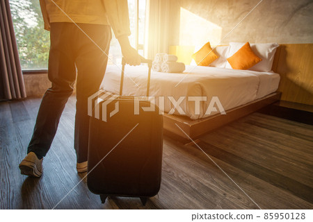 Cropped shot of tourist woman pulling her luggage to her hotel bedroom after check-in. Conceptual of travel and vacation. 85950128