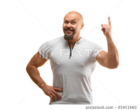 Happy smiling brutal man 40 years old looking at camera and keeping finger in air - he have a great idea. Happy smiling brutal man 40 years old looking at camera and keeping finger in air - he have a great idea. 85951660