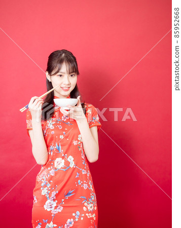 紅色背景下，由美麗的旗袍女性書寫的傳統筷子和日本碗筷。 85952668