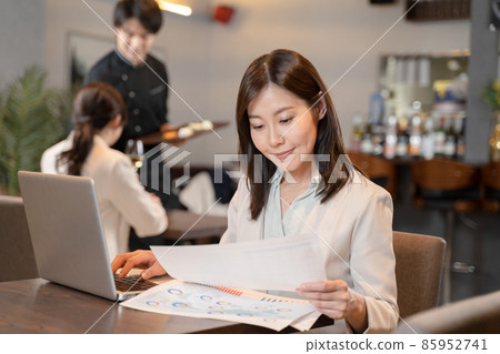 Female doing remote work at a restaurant Female doing remote work at a restaurant 85952741