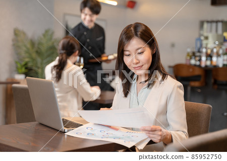 Female doing remote work at a restaurant Female doing remote work at a restaurant 85952750