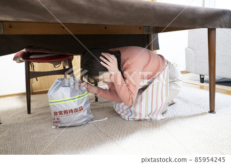 地震後一名婦女在桌下撤離 地震後一名婦女在桌下撤離 85954245