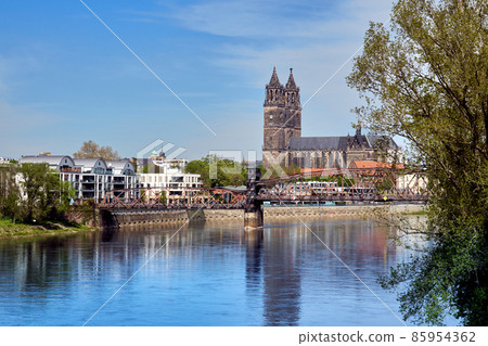 View over the river Elbe to an old iron railroad bridge and the cathedral of Magdeburg, Germany View over the river Elbe to an old iron railroad bridge and the cathedral of Magdeburg, Germany 85954362