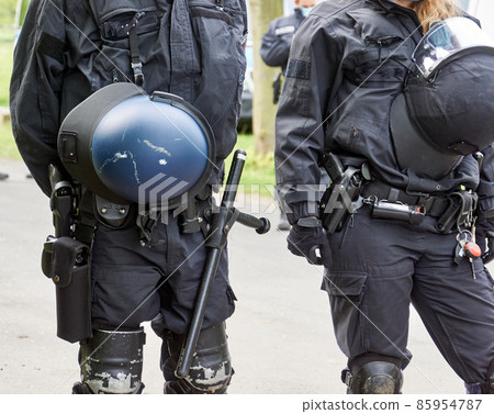 Uniformed German police officers with helmets, batons and knee pads Uniformed German police officers with helmets, batons and knee pads 85954787