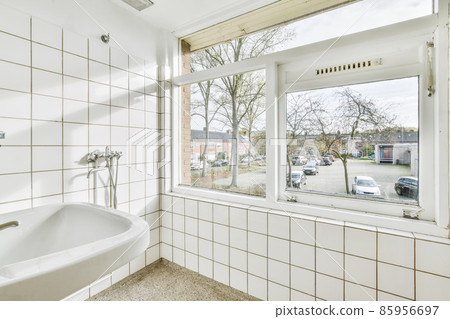 Bathroom with white tiles and a window to the street 85956697