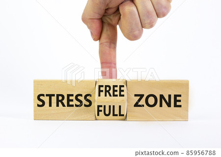Stress free zone symbol. Doctor turns a cube and changes words 'stress full zone' to 'stress free zone'. Beautiful white background. Psychological, business and stress free zone concept. Copy space. Stress free zone symbol. Doctor turns a cube and changes words 'stress full zone' to 'stress free zone'. Beautiful white background. Psychological, business and stress free zone concept. Copy space. 85956788