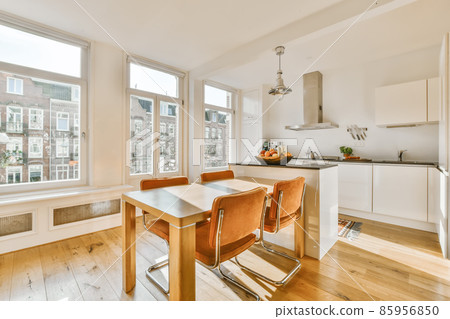 Delightful daylight dining room with wooden table Delightful daylight dining room with wooden table 85956850