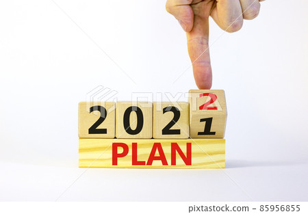 2022 plan new year symbol. Businessman turns a wooden cube and changes words 'Plan 2021' to 'Plan 2022'. Beautiful white background, copy space. Business, 2022 plan new year concept. 2022 plan new year symbol. Businessman turns a wooden cube and changes words 'Plan 2021' to 'Plan 2022'. Beautiful white background, copy space. Business, 2022 plan new year concept. 85956855