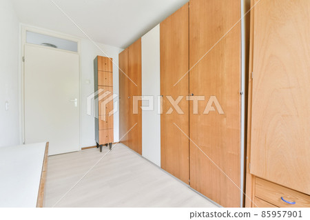 Long room with a full-length wooden wardrobe Long room with a full-length wooden wardrobe 85957901