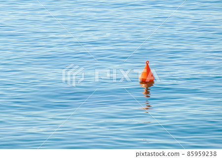 Red buoy floating on the surface of blue water in the sea. Red buoy floating on the surface of blue water in the sea. 85959238