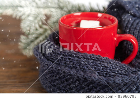 Knitted scarf and red mug with hot chocolate. 85960795