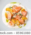 Salmon fillet with baked potatoes and creamy sauce. 85961080