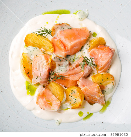 Salmon fillet with baked potatoes and creamy sauce. 85961080