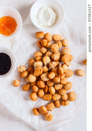 Shi-baursak, Kazakh traditional fried dounuts served on a parchment paper on a white background. Festive sweet baking. Shi-baursak, Kazakh traditional fried dounuts served on a parchment paper on a white background. Festive sweet baking. 85961427