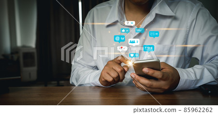 Business man using mobile phone for social media marketing concept with notification varieties icons of like love check in mail message comment and star above smartphone screen. Community social. 85962262