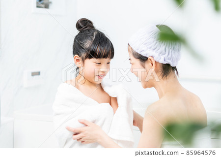 Mother wiping her daughter after taking a bath 85964576